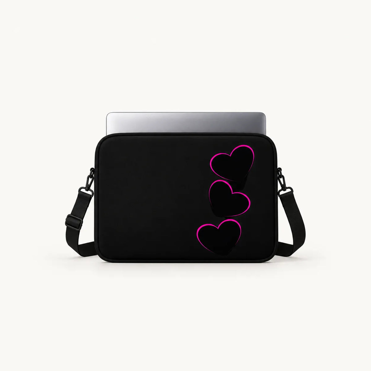 A black laptop sleeve with three stacked pink heart outlines on the front, shown with a silver laptop inserted on a light gray background.