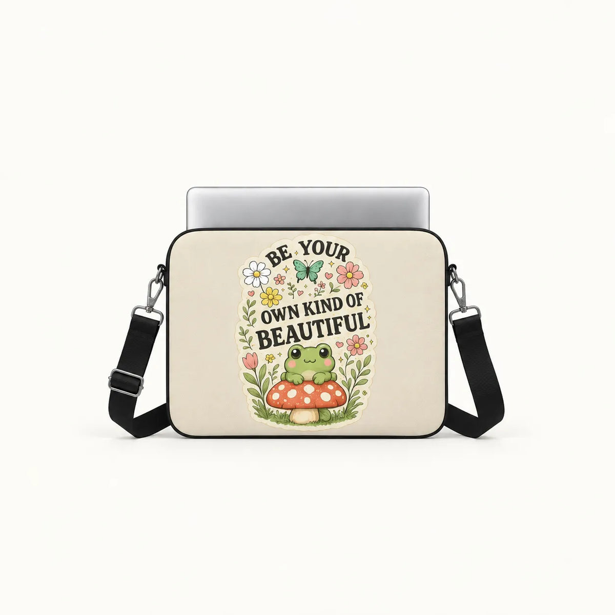 Cute green frog sitting on a red toadstool surrounded by flowers and Be Your Own Kind of Beautiful typography on cream padded laptop sleeve by SLEEVER