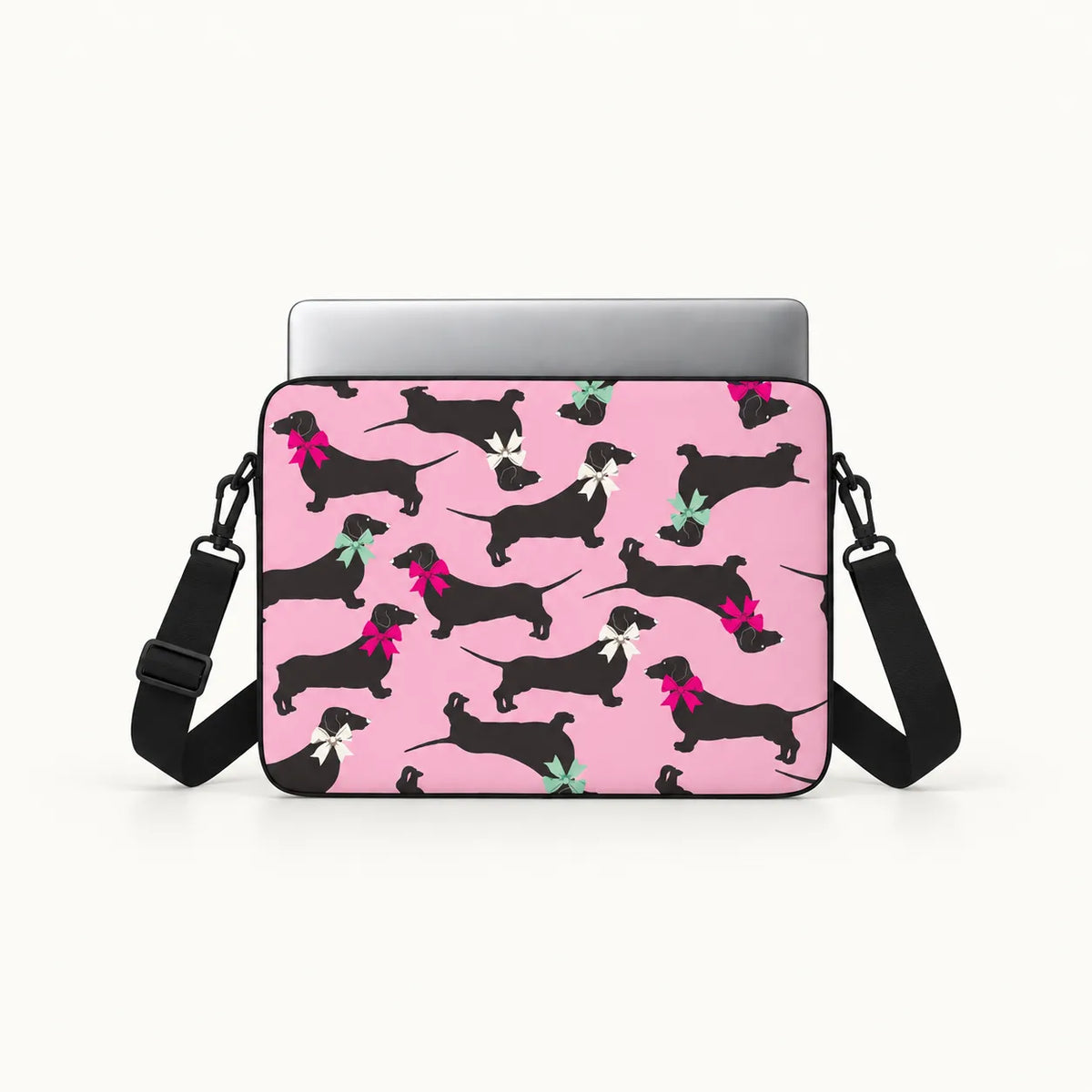 Seamless pattern of black dachshund dogs wearing colorful pink white and green ribbons on a pink padded laptop sleeve by SLEEVER