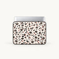 A laptop sleeve with a dense black and pink floral pattern on a light cream background, shown with a silver laptop inside against a light gray studio background.