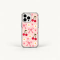 A clear-sided phone case with a light pink back decorated with a repeating pattern of red cherries, pink bows, small pink hearts, and white daisies, shown on a white background.