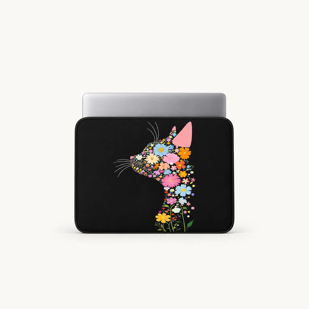 A black laptop sleeve featuring a stylized cat silhouette filled with colorful flowers, shown with a silver laptop inside on a light gray background.
