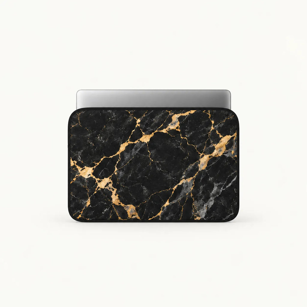Front-view mock-up of SLEEVER padded laptop sleeve in black and gold marble pattern with silver laptop inside