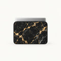 Front-view mock-up of SLEEVER padded laptop sleeve in black and gold marble pattern with silver laptop inside