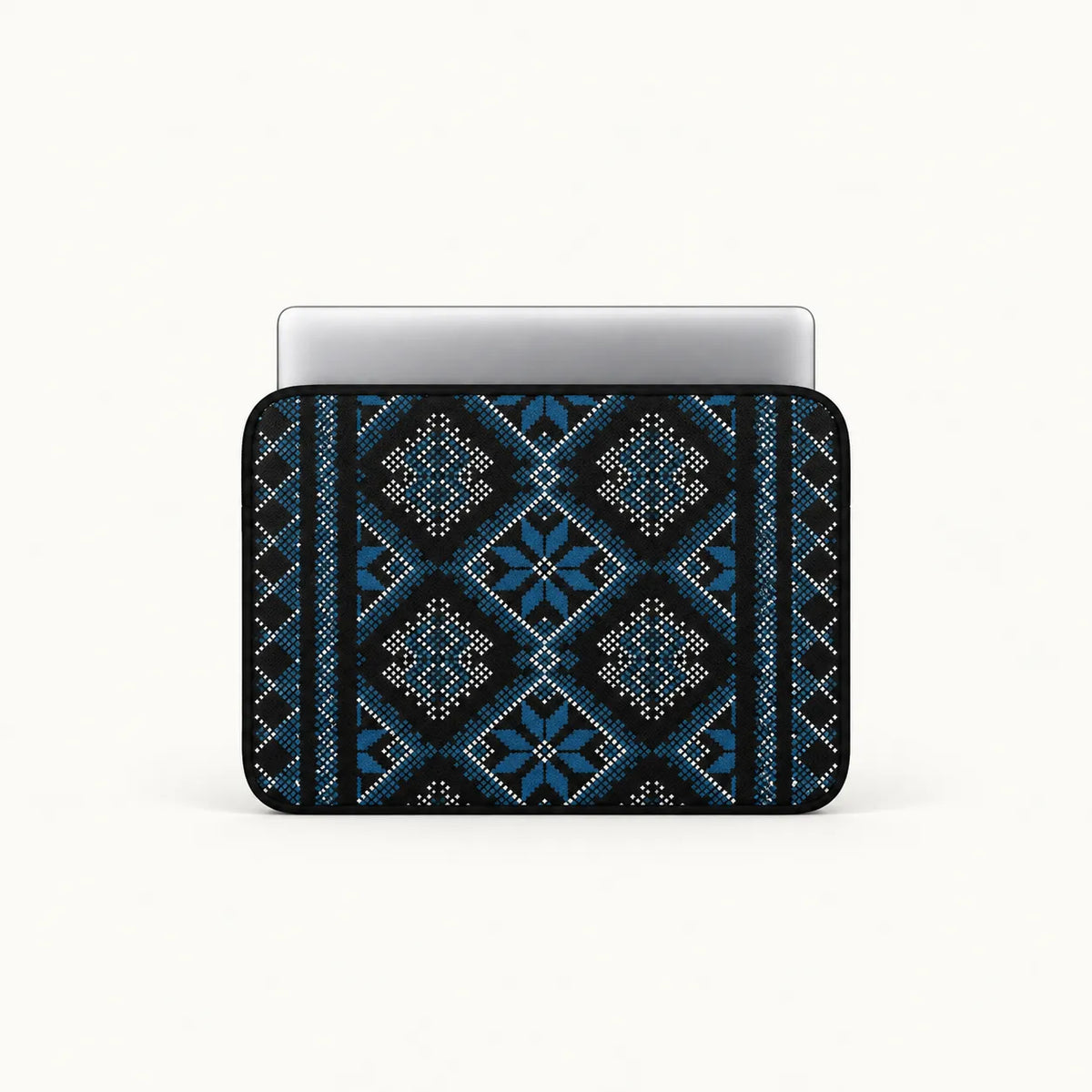 A laptop sleeve featuring a blue and black geometric tribal pattern, shown with a silver laptop inserted on a clean white background.