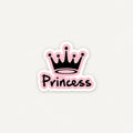 A die-cut sticker featuring a black crown above the word 'Princess' in black script with a pink outline, shown on a light gray background.