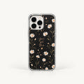 A clear phone case with a black floral print featuring white daisies, gold leaves, and the phrase 'You are this' in gold script, shown on a light gray background.
