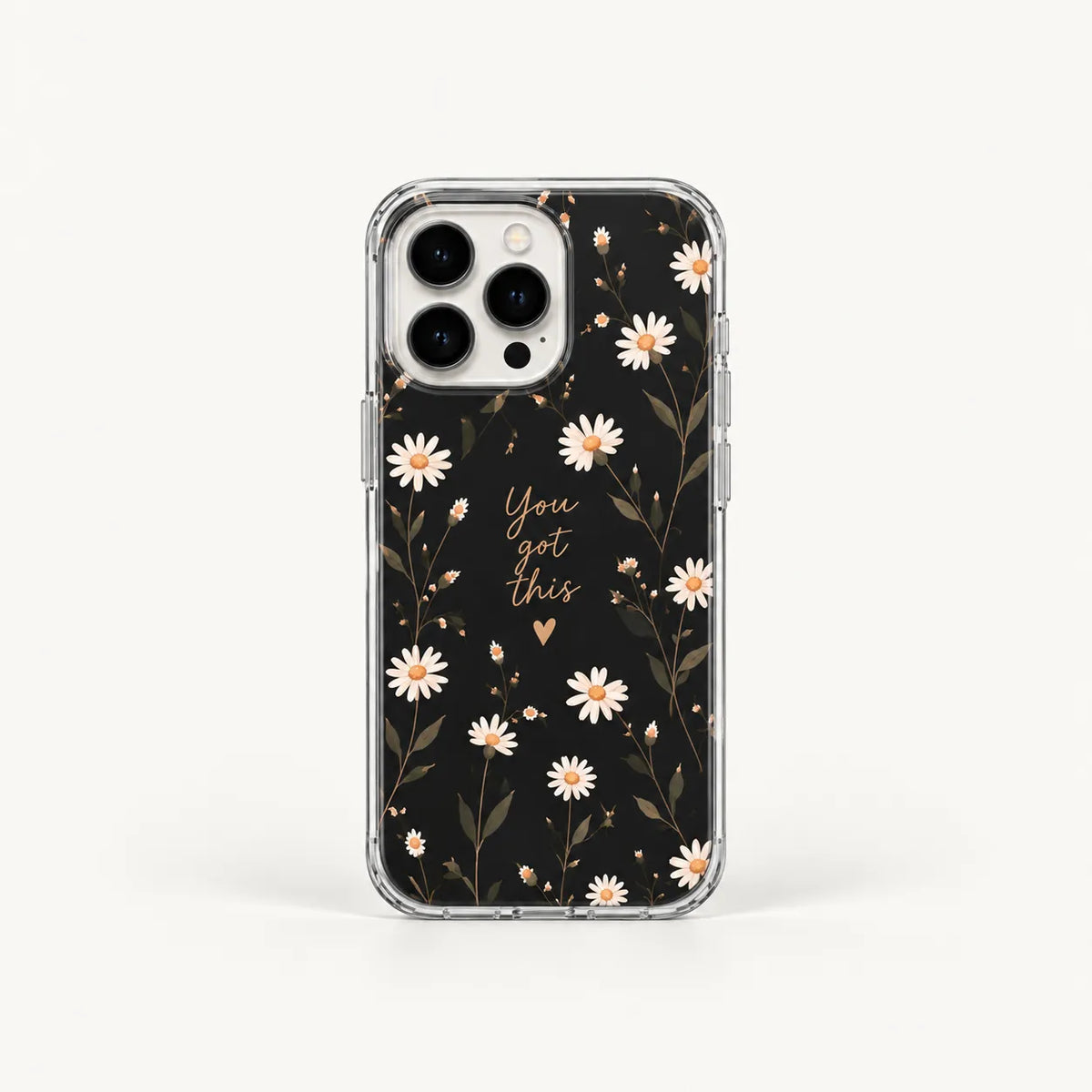A clear phone case with a black floral print featuring white daisies, gold leaves, and the phrase 'You are this' in gold script, shown on a light gray background.