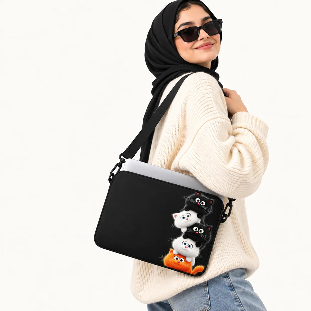 Stacked cute cartoon black, white, and orange kittens on a black padded laptop sleeve by SLEEVER