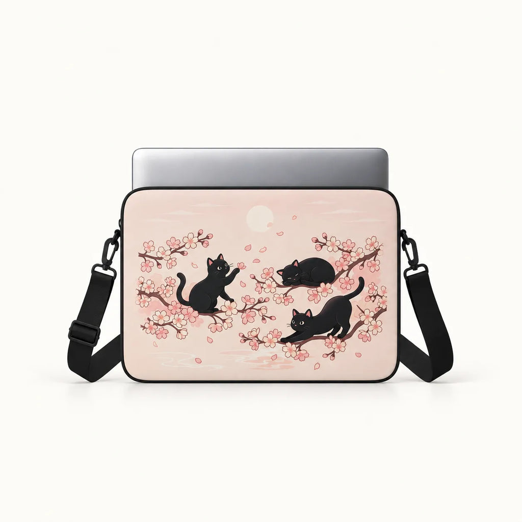 Three black cats playing among Japanese cherry blossom sakura branches on a pastel pink padded laptop sleeve by SLEEVER