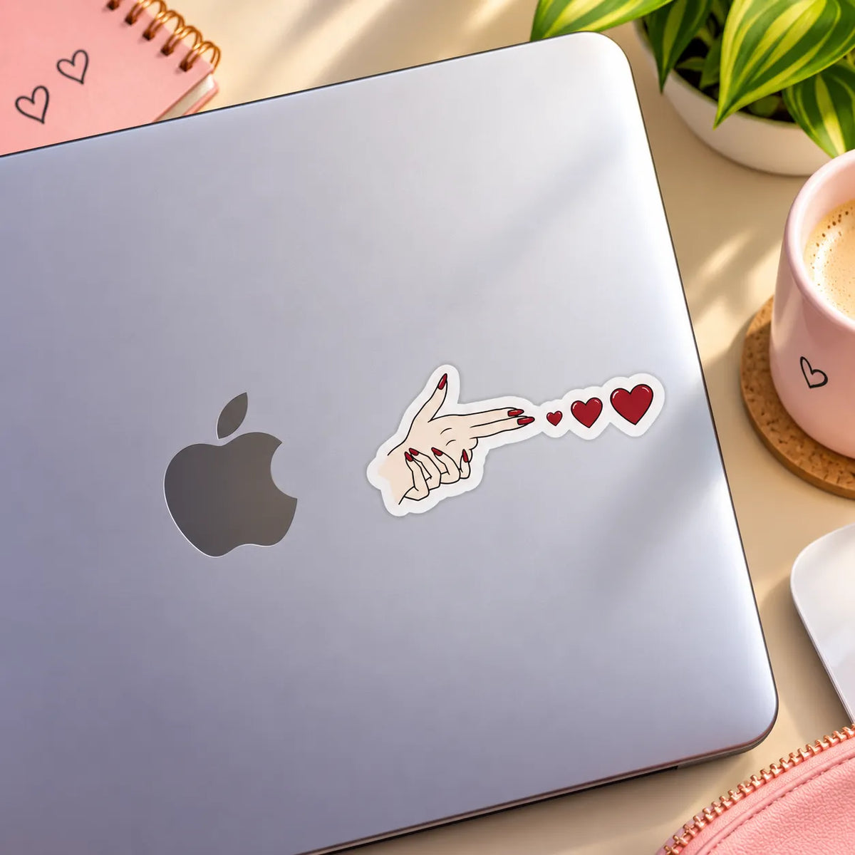 Female hand in a finger gun gesture shooting red hearts sticker with red nails by SLEEVER   
