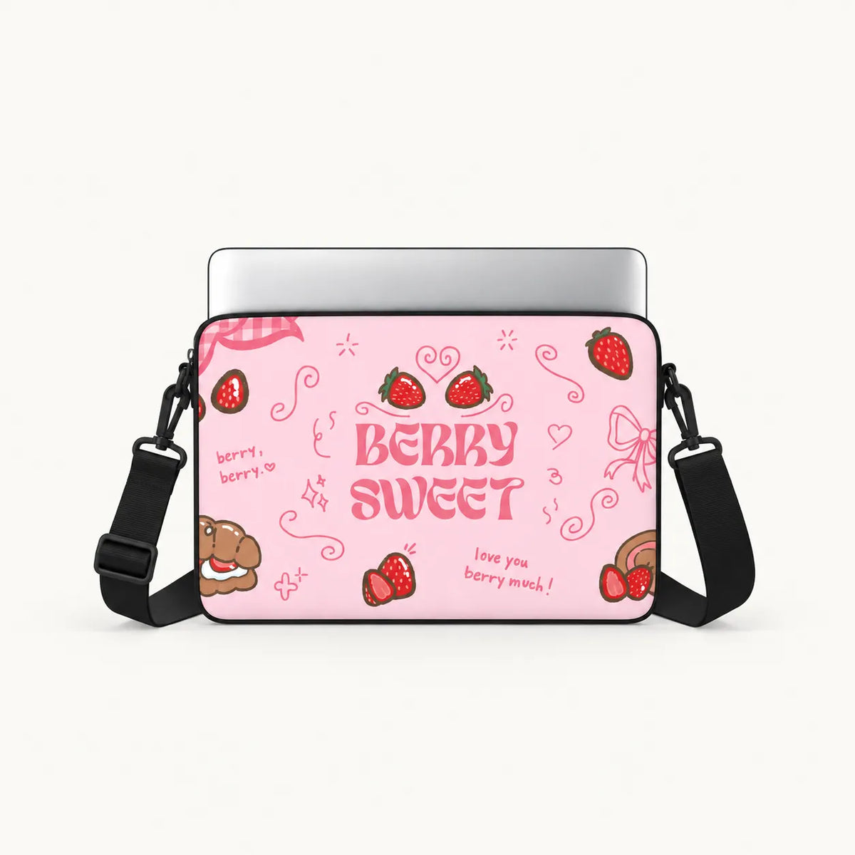 A pink laptop sleeve with a strawberry-themed 'BERRY BERRY SWEET' design, shown with a silver laptop and black shoulder strap on a light gray background.