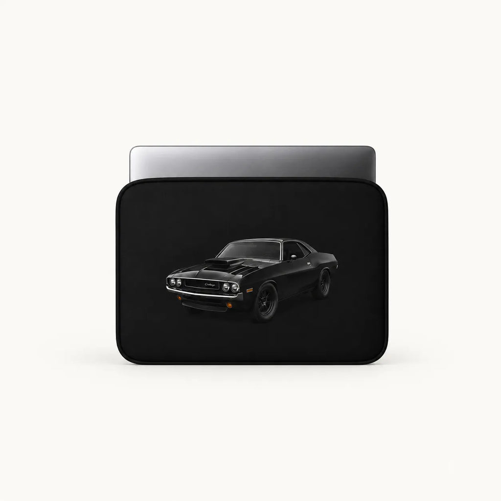 A black laptop sleeve featuring a graphic print of a black muscle car, shown with a silver laptop inside on a light off-white background.