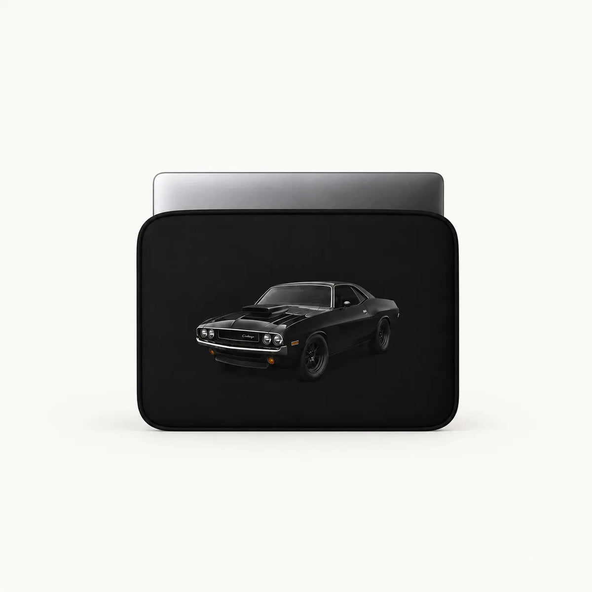 A black laptop sleeve featuring a graphic print of a black muscle car, shown with a silver laptop inside on a light off-white background.