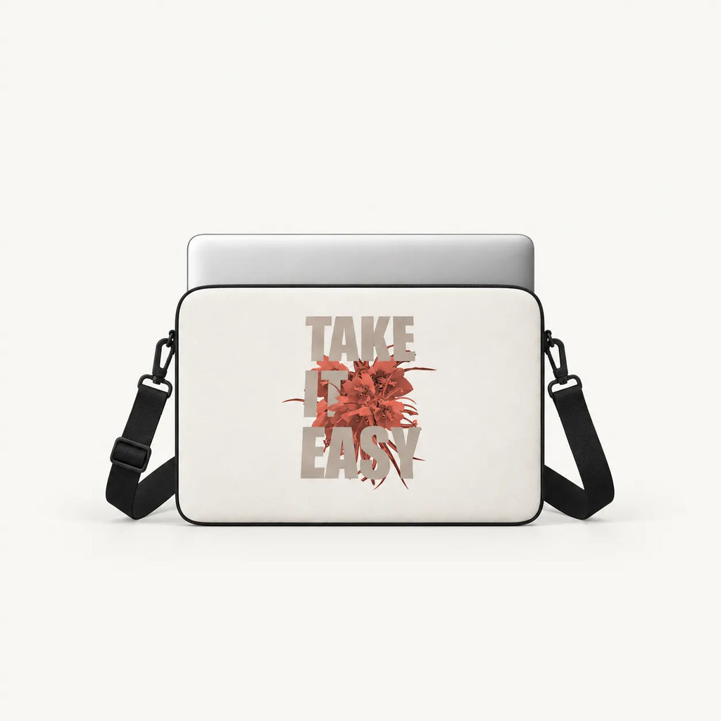 A white laptop sleeve with a black strap, featuring a graphic print of a red flower and the text 'TAKE IT EASY' in a distressed beige font, shown on a light gray background.