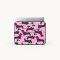 Seamless pattern of black dachshund dogs wearing colorful pink white and green ribbons on a pink padded laptop sleeve by SLEEVER