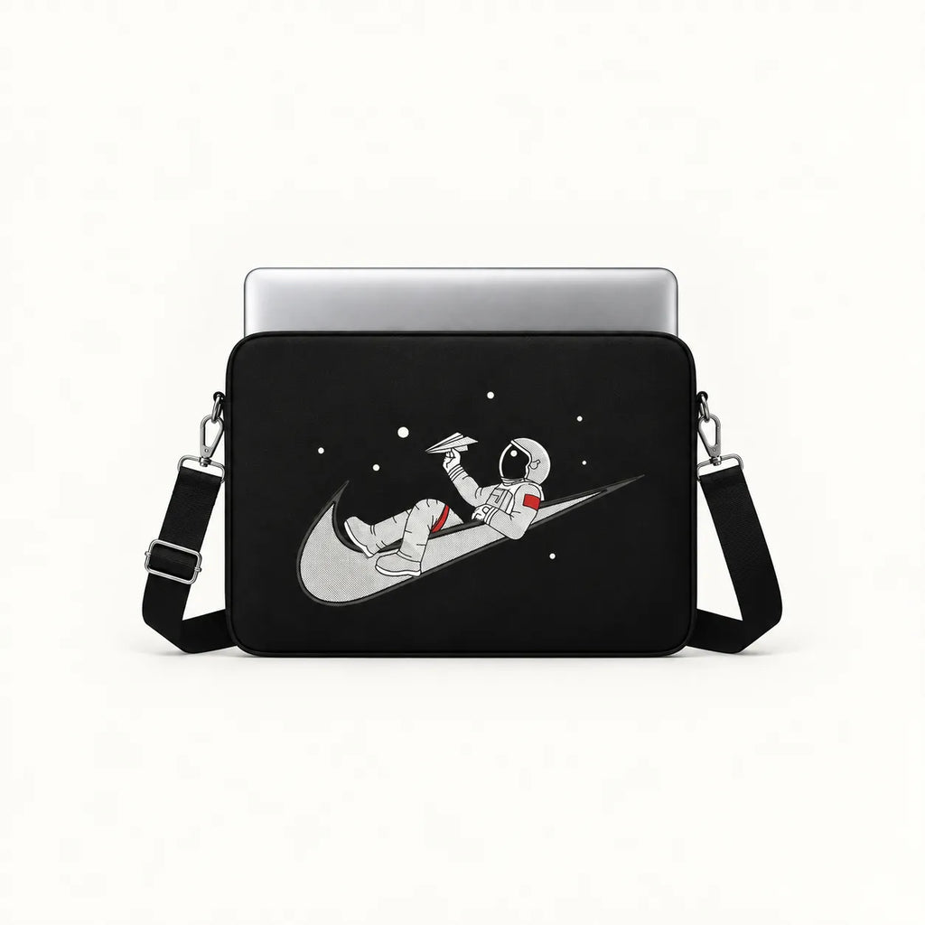 Illustration of an astronaut relaxing on a swoosh logo holding a paper plane in space on a black padded laptop sleeve by SLEEVER