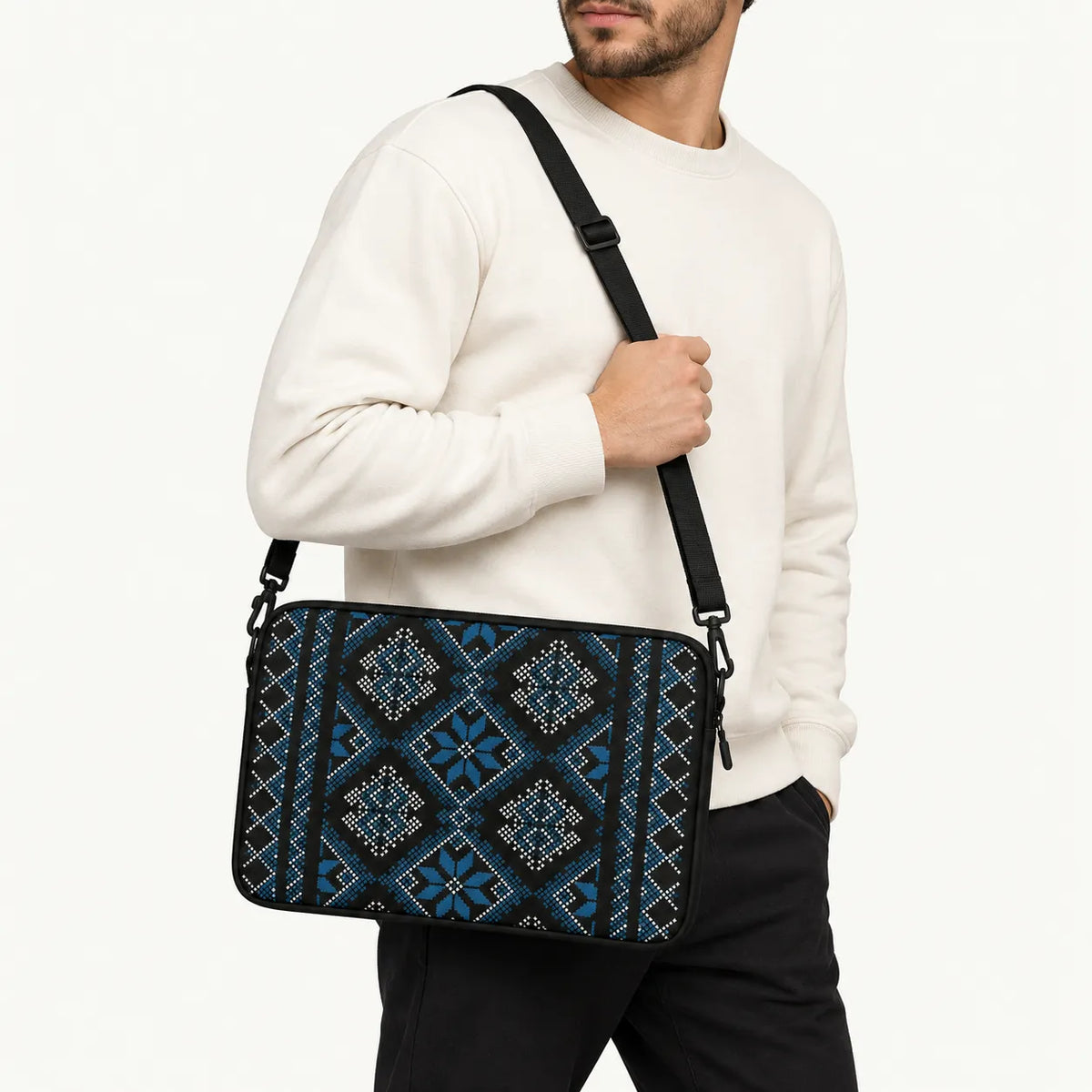 Blue and white traditional Palestinian Tatreez cross-stitch pattern printed on black padded laptop sleeve by SLEEVER