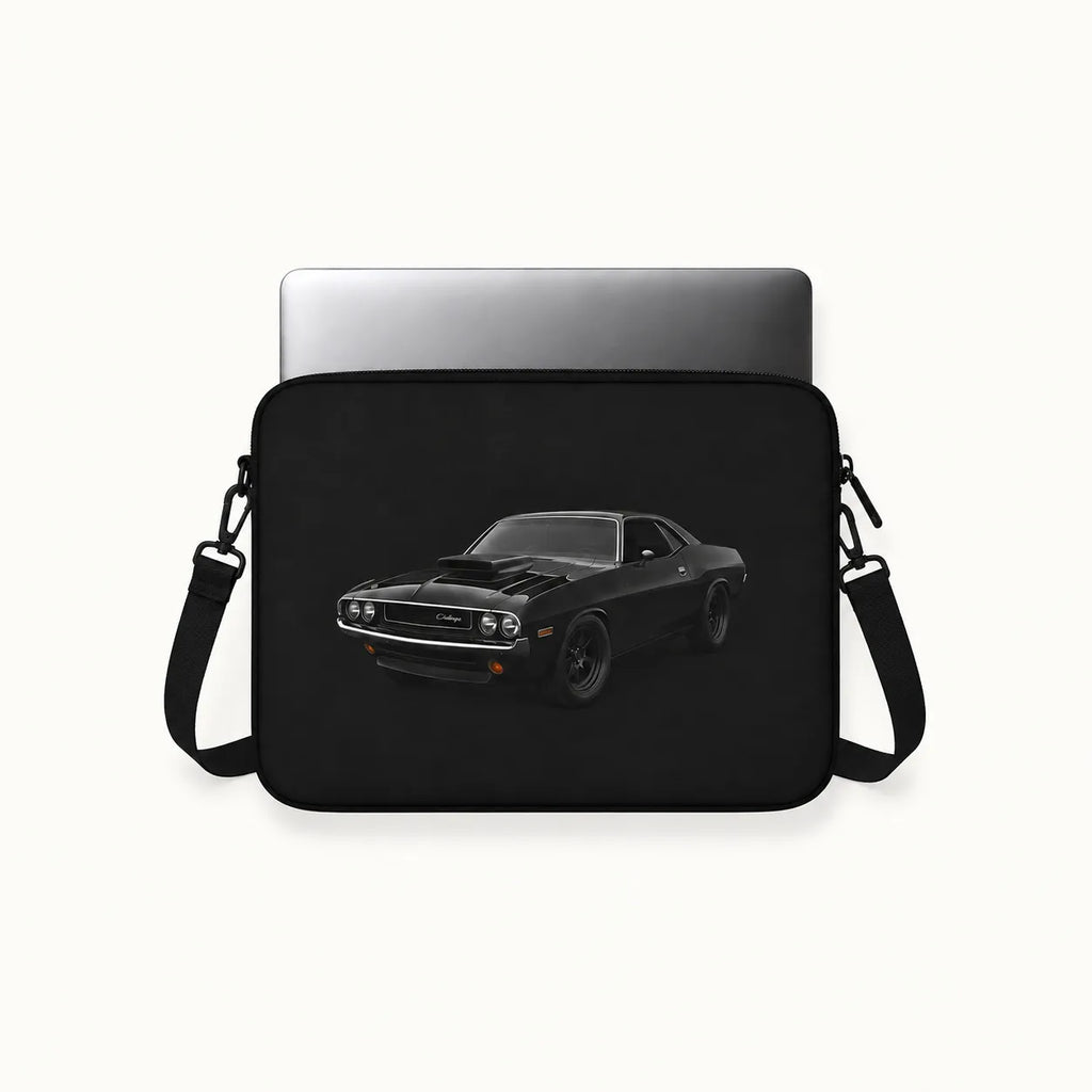 A black laptop sleeve featuring a printed graphic of a black muscle car, shown with a silver laptop inserted on a light off-white background.
