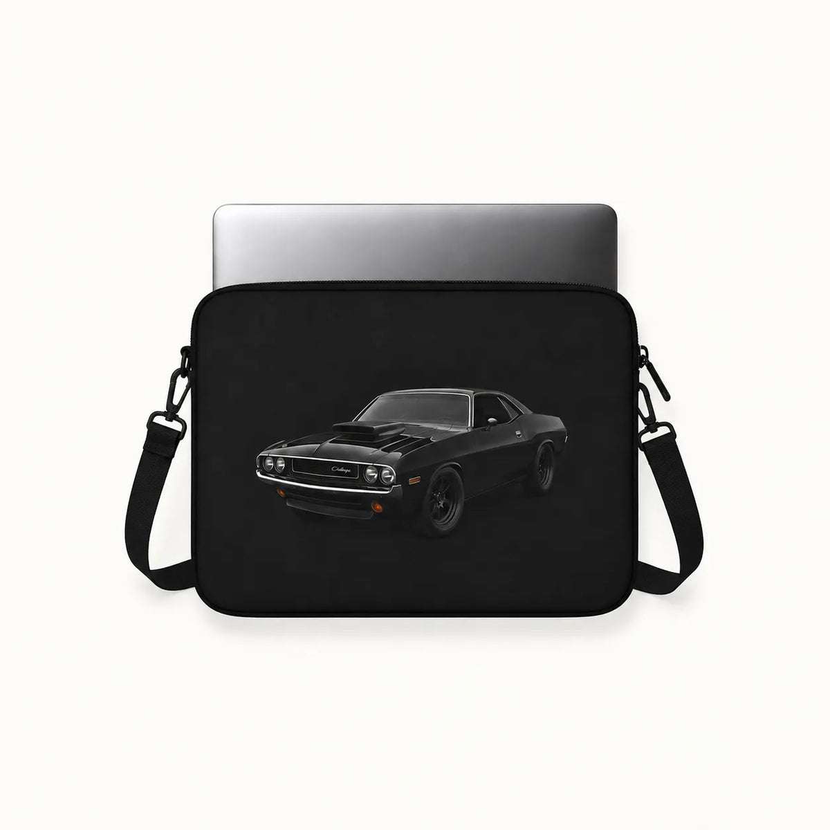 A black laptop sleeve featuring a printed graphic of a black muscle car, shown with a silver laptop inserted on a light off-white background.