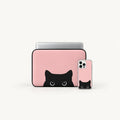 A pink laptop sleeve and matching phone case with a black cat face peeking out from the bottom, shown on a clean white background.