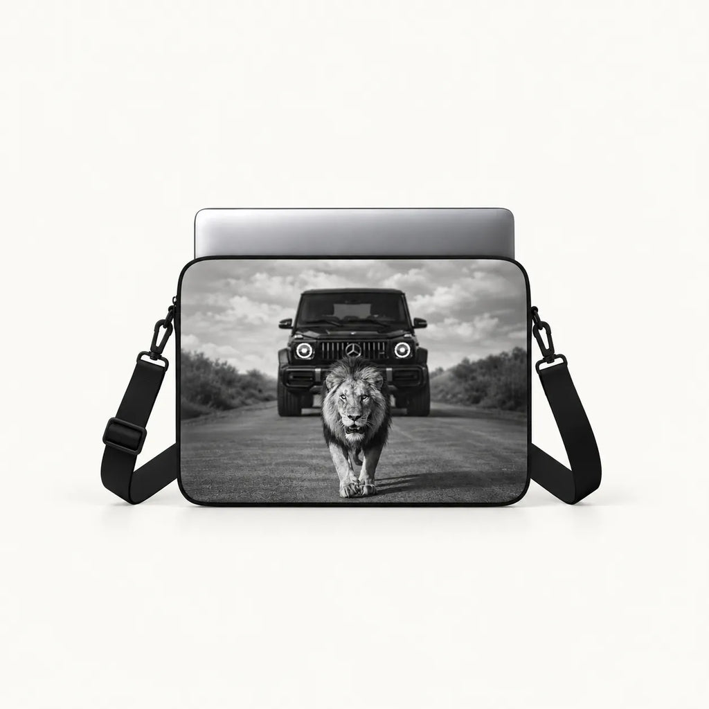 Powerful male lion walking on a road in front of a Mercedes G-Wagon car in dramatic black and white print on a padded laptop sleeve by SLEEVER