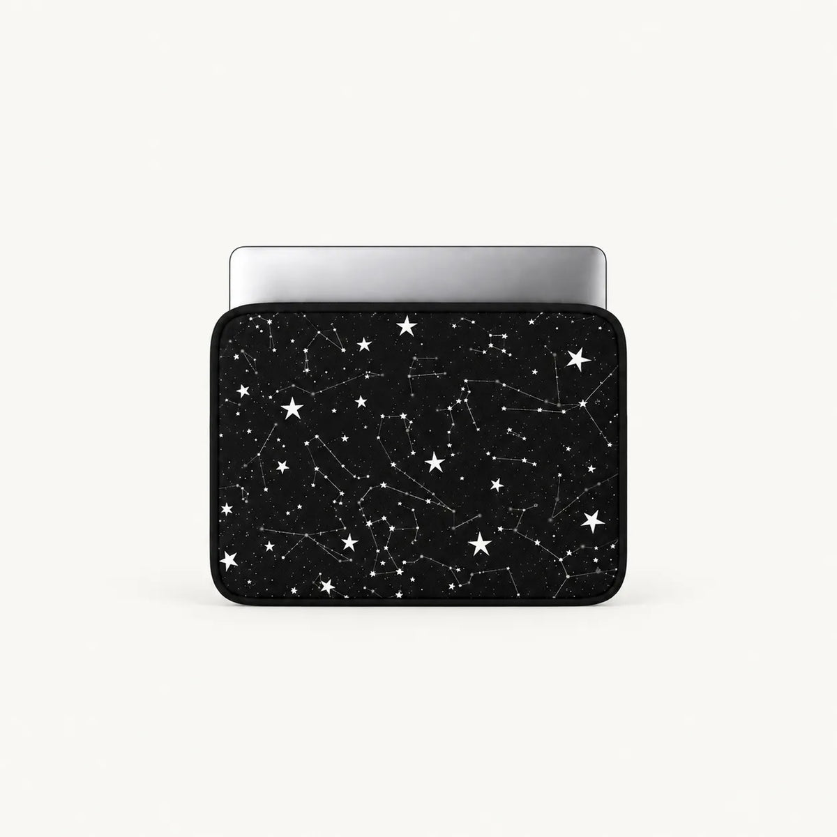 A laptop sleeve featuring a black space design with white stars and constellation patterns, shown with a silver laptop inside on a light gray background.