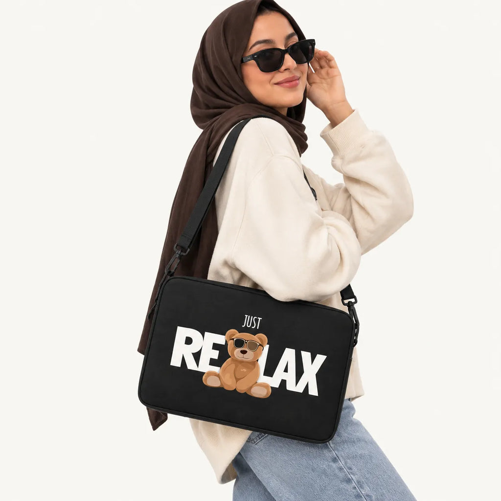 Cool teddy bear wearing sunglasses sitting with JUST RELAX typography on a black padded laptop sleeve by SLEEVER