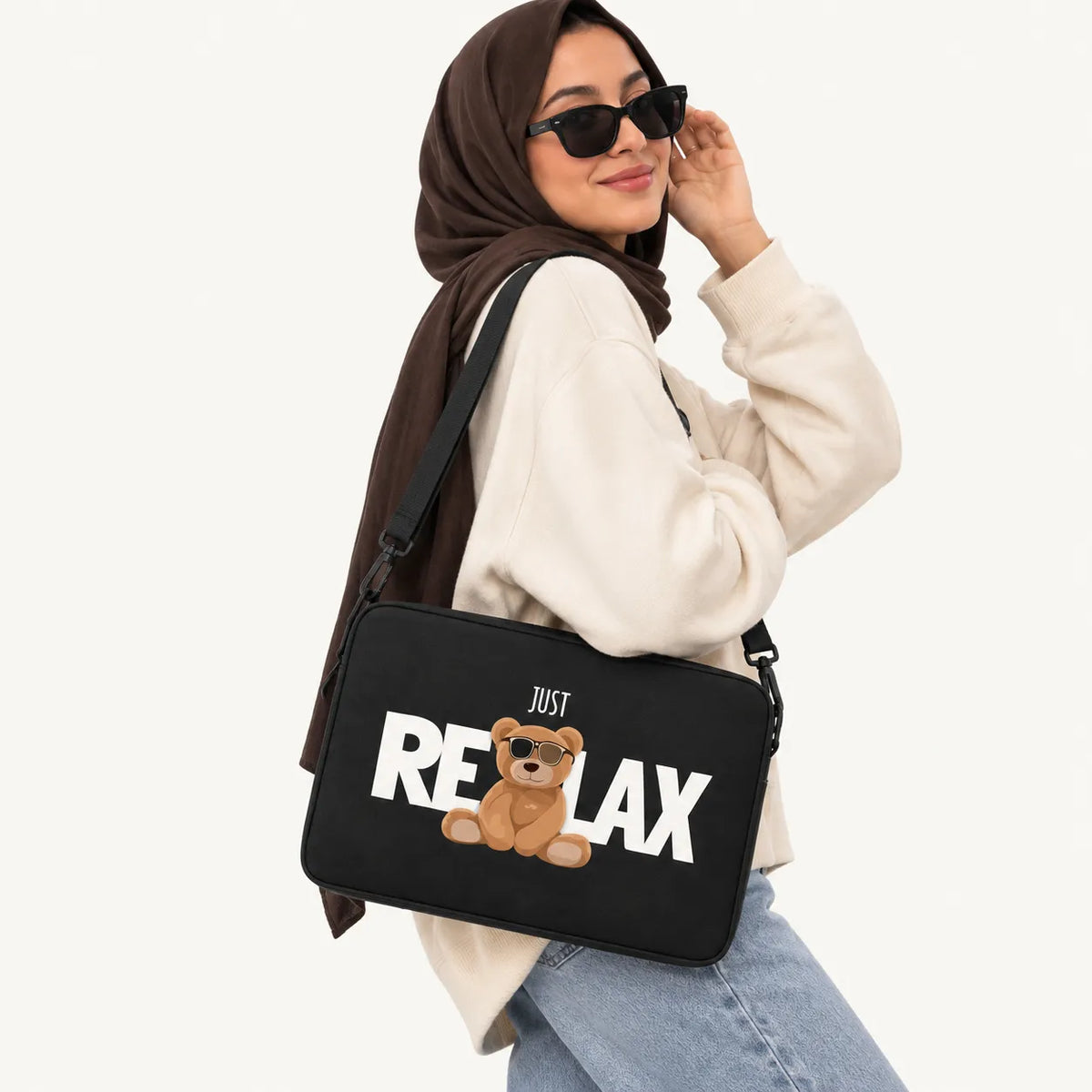 Cool teddy bear wearing sunglasses sitting with JUST RELAX typography on a black padded laptop sleeve by SLEEVER
