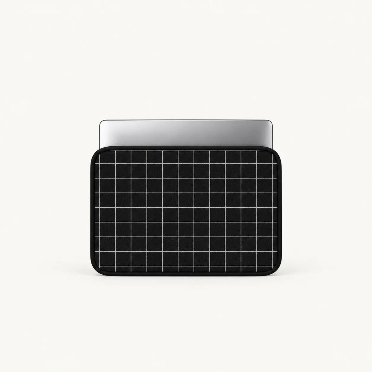 A black laptop sleeve with a white grid pattern, shown with a silver laptop partially inserted, on a clean off-white background.