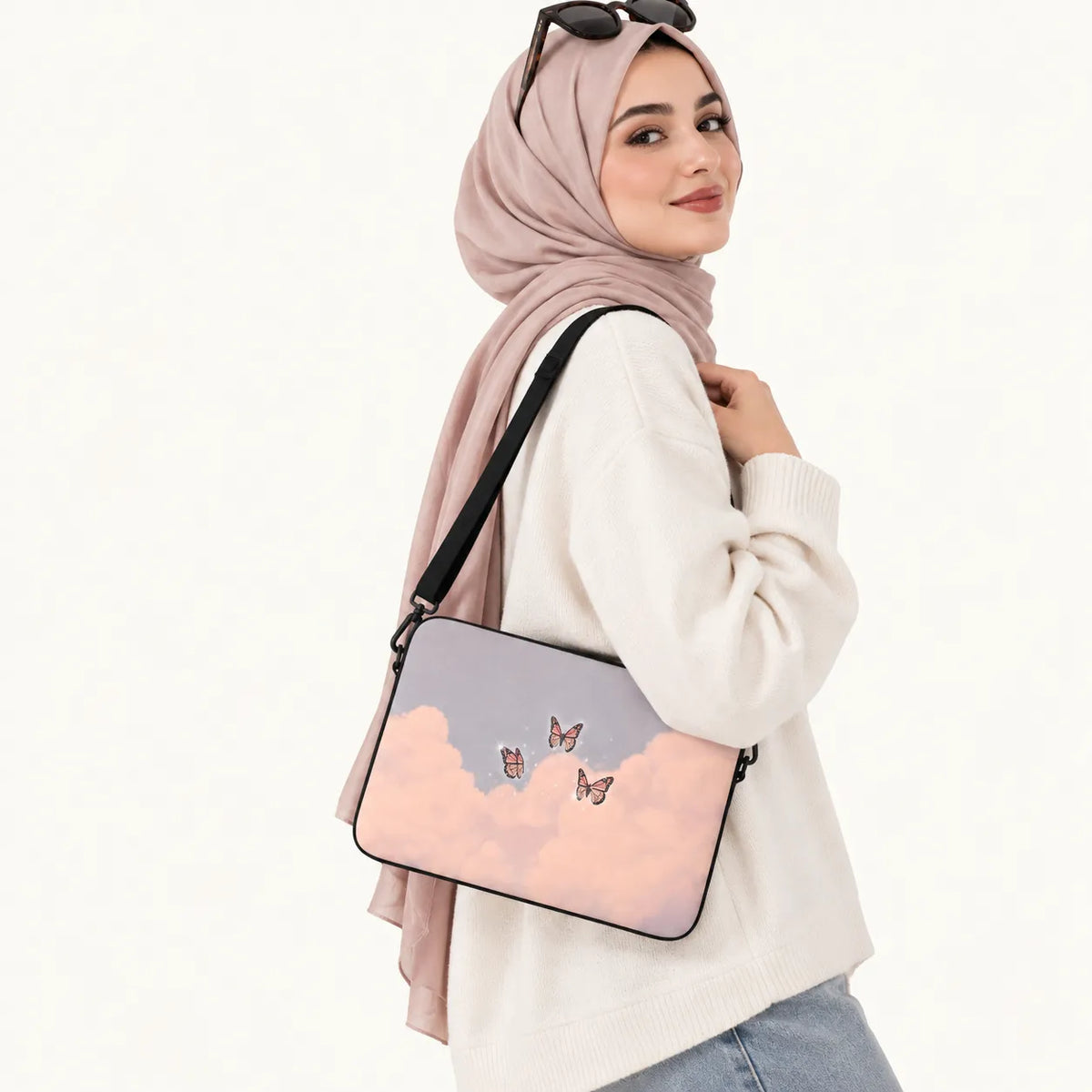 Pink butterflies flying among soft pink clouds in a pastel sky printed on a padded laptop sleeve by SLEEVER