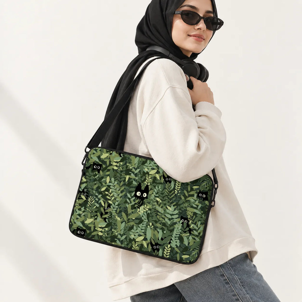 Cute black cats hiding in green leaves pattern on a padded laptop sleeve by SLEEVER
