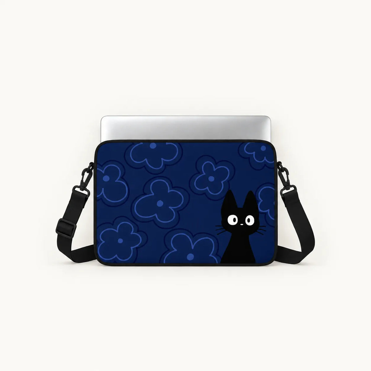 A laptop sleeve featuring a dark blue background with light blue floral patterns and a black cat character peeking from the bottom right, shown with a silver laptop on top against a light off-white background.