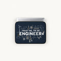 White "TRUST ME, I'M AN ENGINEER" text surrounded by scientific formulas, equations, circuit diagrams, and gear icons on a navy blue padded laptop sleeve by SLEEVER   