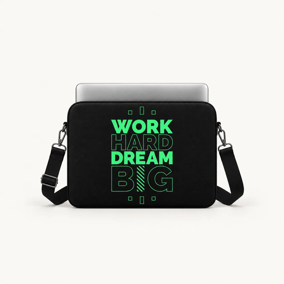 A black laptop sleeve with a silver laptop inserted, featuring a bright green graphic that reads 'WORK HARD DREAM BIG' on the front. The sleeve has a black shoulder strap and is photographed against a clean, off-white background.