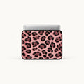A laptop sleeve featuring a pink and black leopard print pattern, shown with a silver laptop inside on a clean white background.