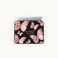 A laptop sleeve featuring a black background decorated with pink metallic butterfly illustrations and the text 'Fly Free! like a butterfly' in pink script. A silver laptop is shown inserted into the sleeve against a clean white background.