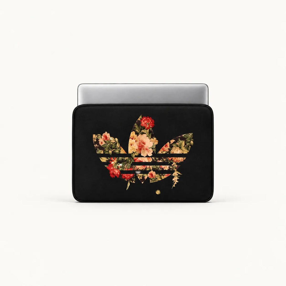 A black laptop sleeve featuring a floral trefoil logo design, shown with a silver laptop partially inserted on a clean white background.