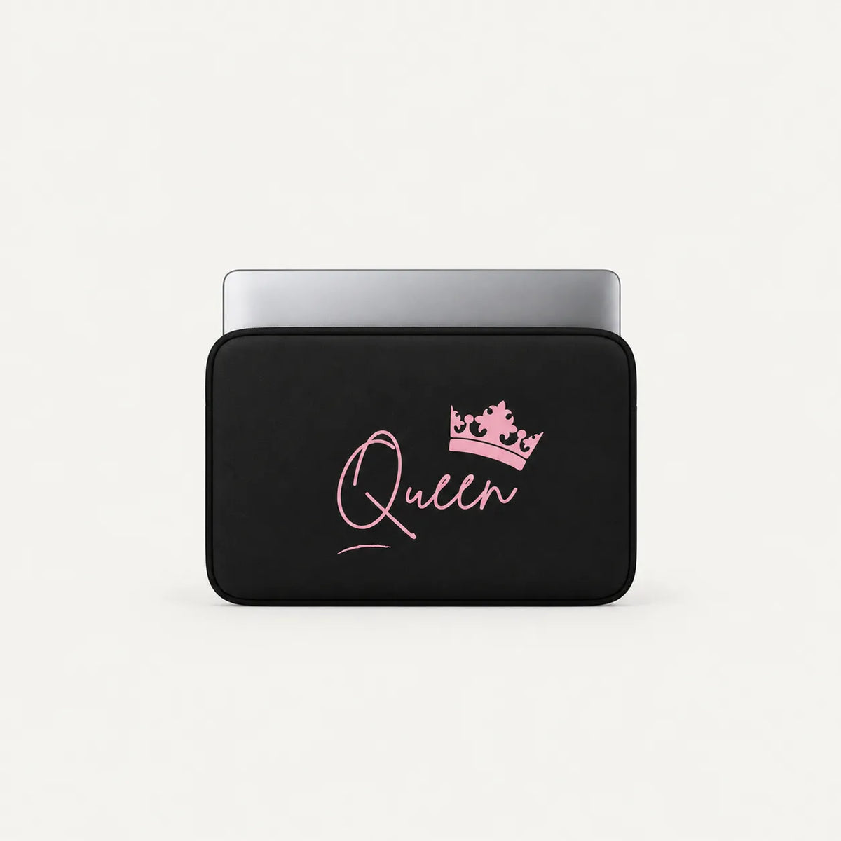A black laptop sleeve with a pink cursive 'Queen' script and a matching pink crown graphic, shown on a light gray background with a silver laptop partially inserted.